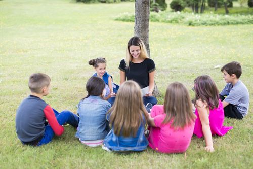 A teacher reading to her class outside